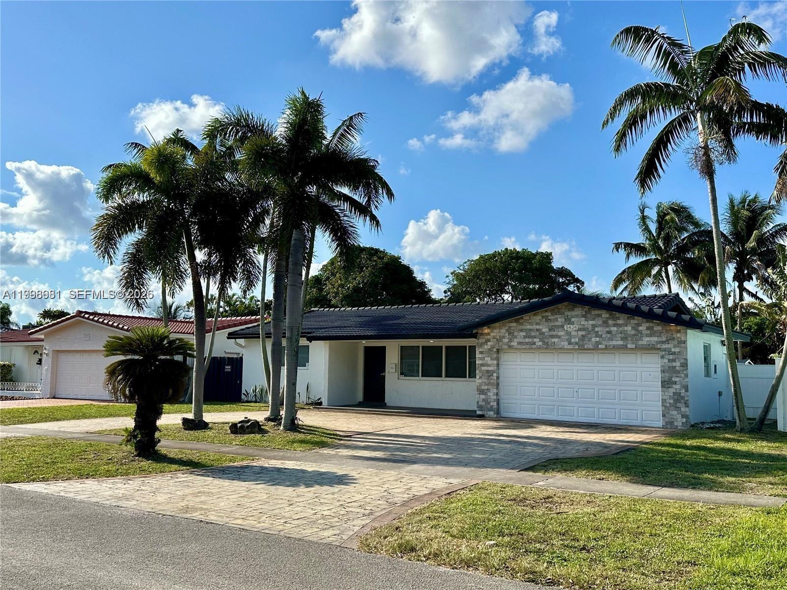 5424 Garfield Street Hollywood, FL 33021 - Photo 1 of 59 a view of a house with a yard and palm trees