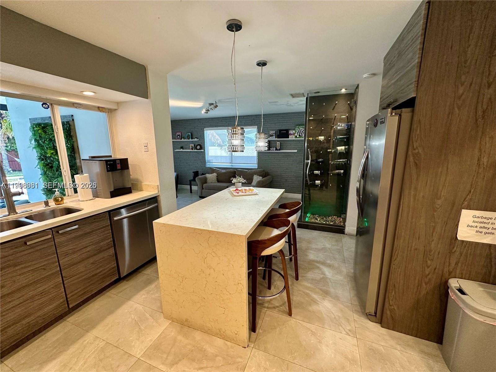 5424 Garfield Street Hollywood, FL 33021 - Photo 25 of 59 a kitchen with a refrigerator a sink and wooden cabinets