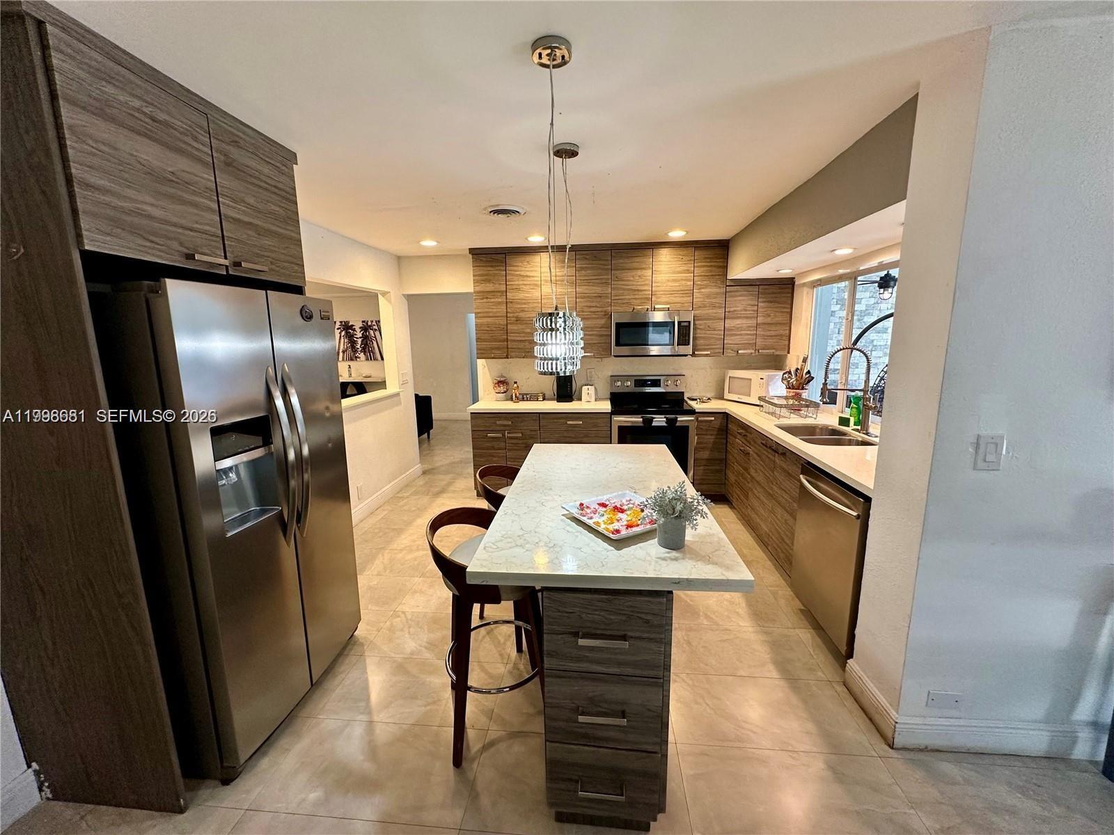 5424 Garfield Street Hollywood, FL 33021 - Photo 28 of 59 a kitchen with stainless steel appliances granite countertop a refrigerator stove and sink