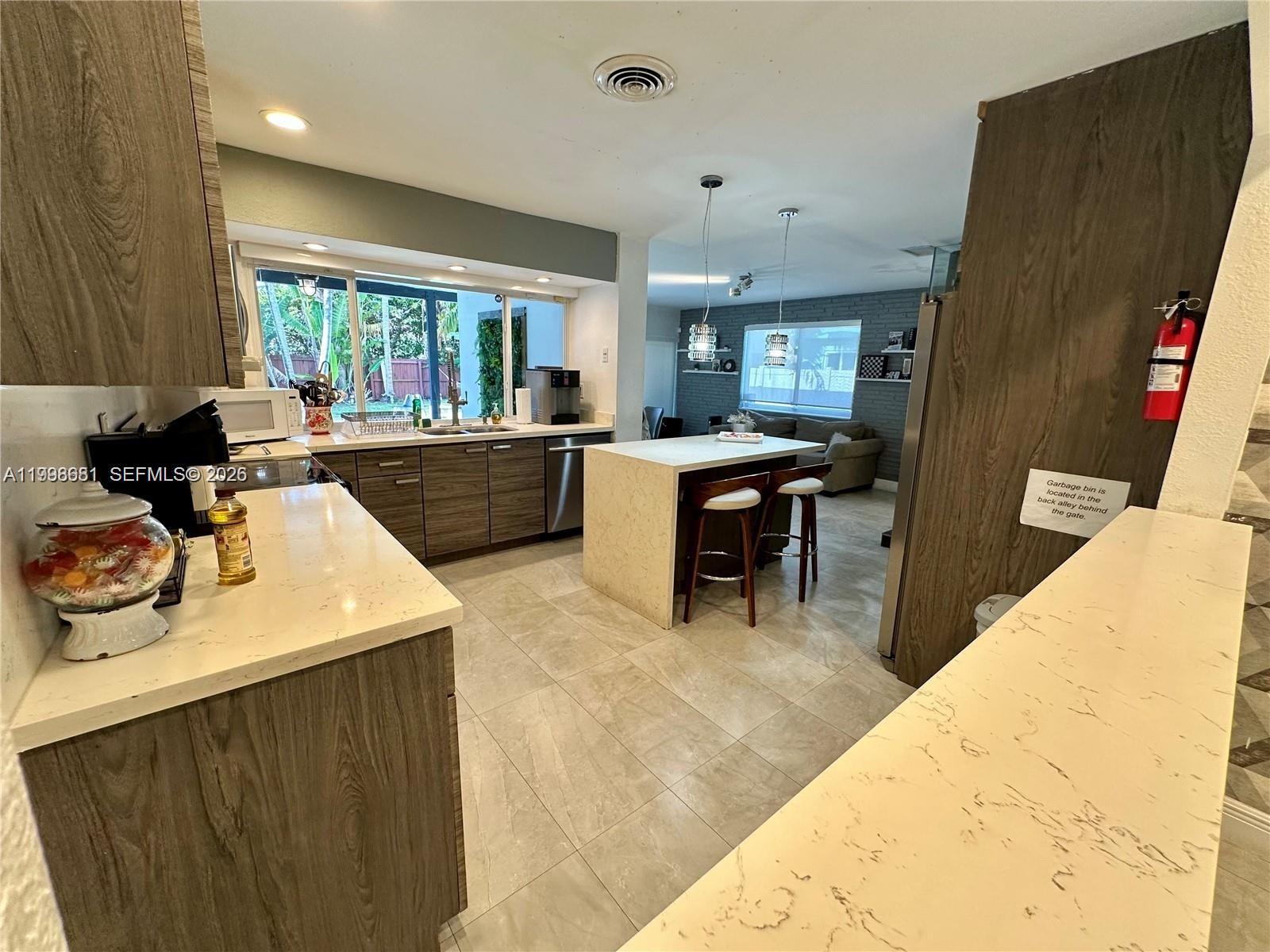 5424 Garfield Street Hollywood, FL 33021 - Photo 29 of 59 a large kitchen with kitchen island a stove a sink a dining table and chair