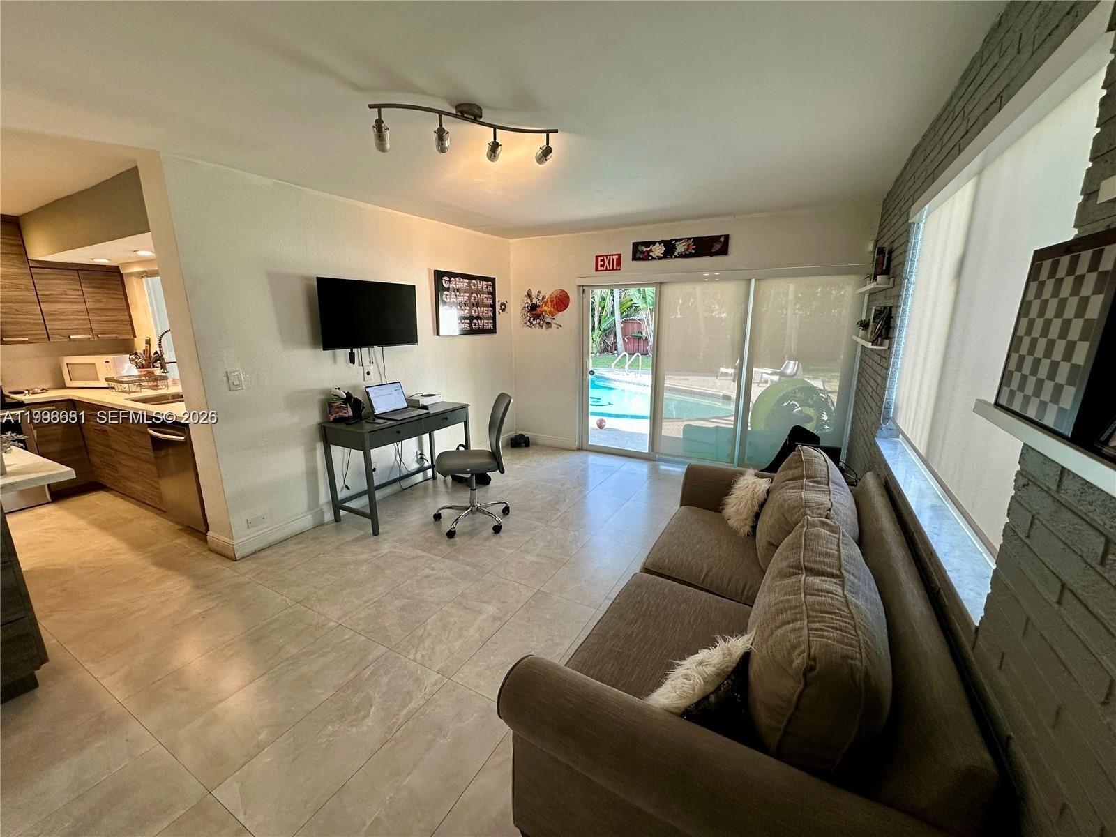 5424 Garfield Street Hollywood, FL 33021 - Photo 32 of 59 a living room with furniture and a flat screen tv