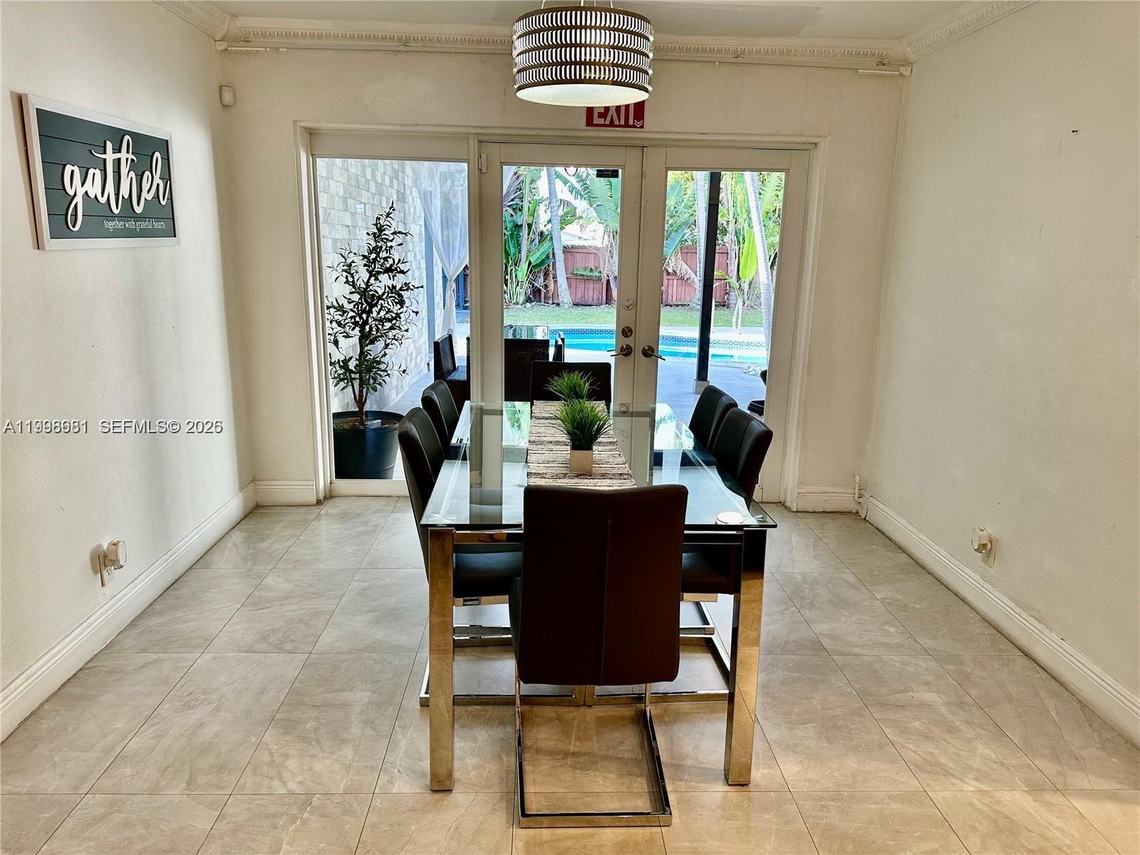 5424 Garfield Street Hollywood, FL 33021 - Photo 39 of 59 a dining room with furniture a chandelier and wooden floor