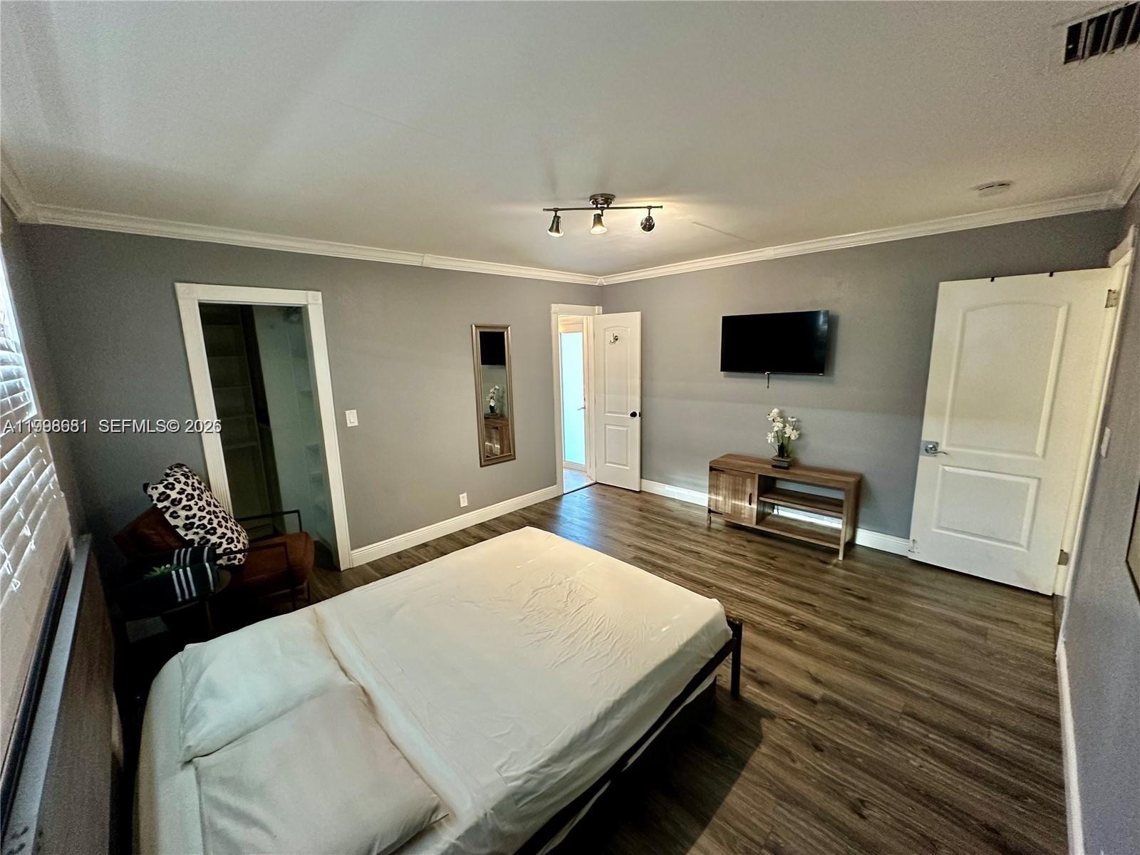 5424 Garfield Street Hollywood, FL 33021 - Photo 47 of 59 a bedroom with a bed and a flat screen tv