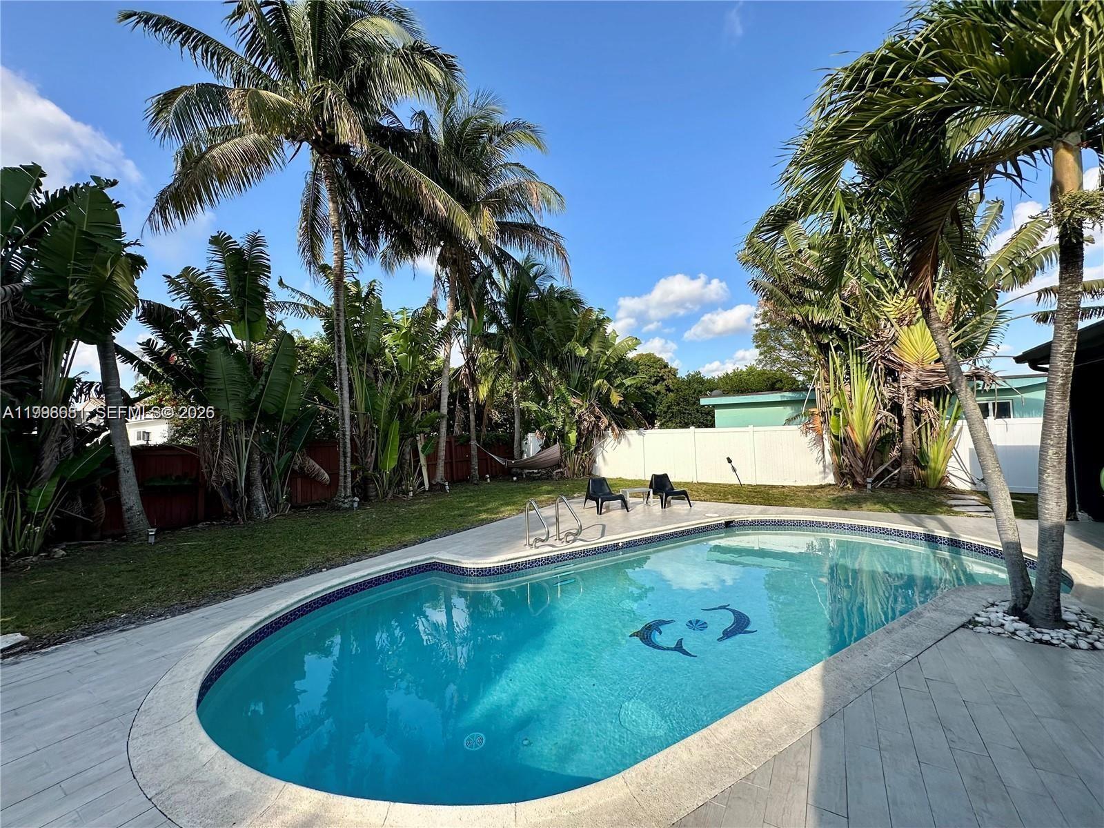 5424 Garfield Street Hollywood, FL 33021 - Photo 8 of 59 a view of a swimming pool with a yard and trees