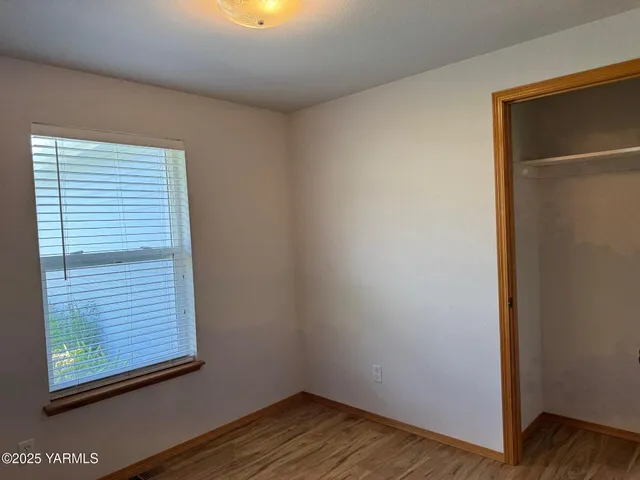 a view of a small space with wooden floor and a window