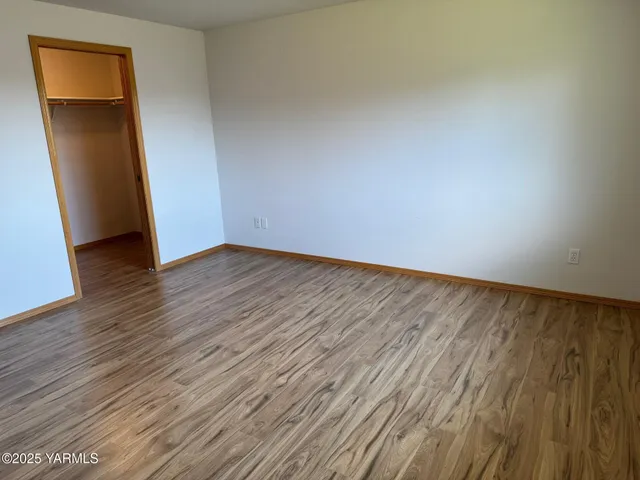 an empty room with wooden floor and closet