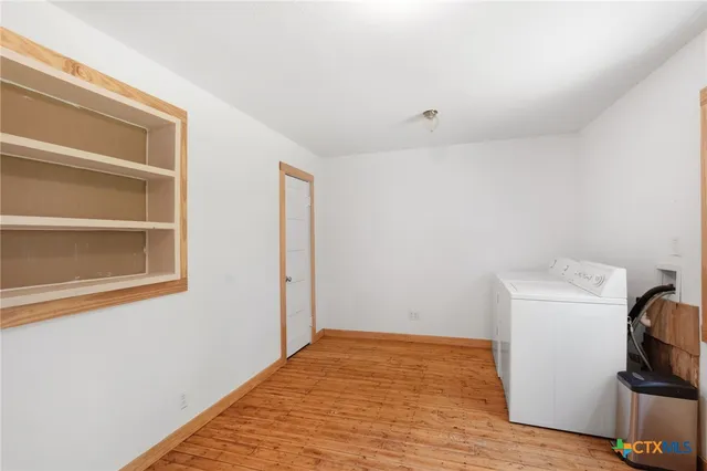 a view of empty room with wooden floor