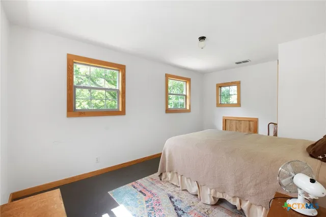 a bedroom with a bed and windows