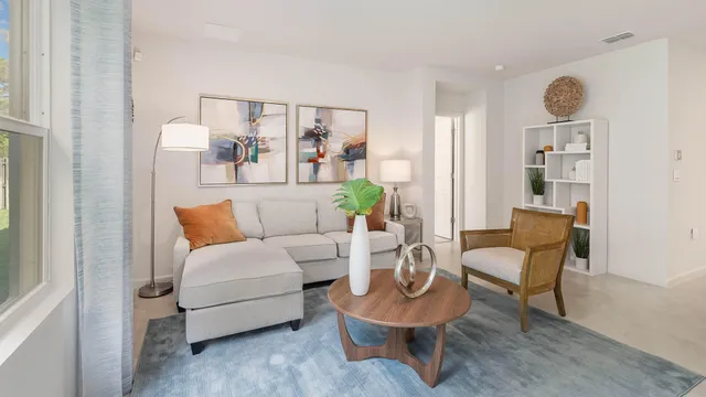 a living room with furniture and a painting on the wall