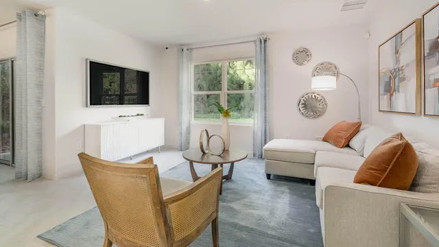 a living room with furniture a flat screen tv and a window