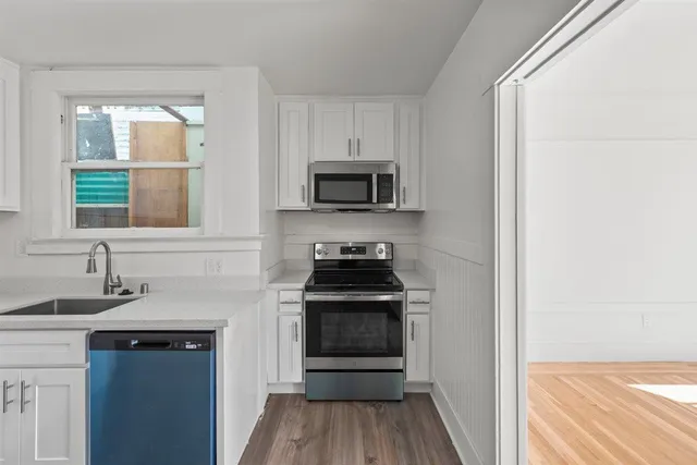 a kitchen with a sink appliances and cabinets
