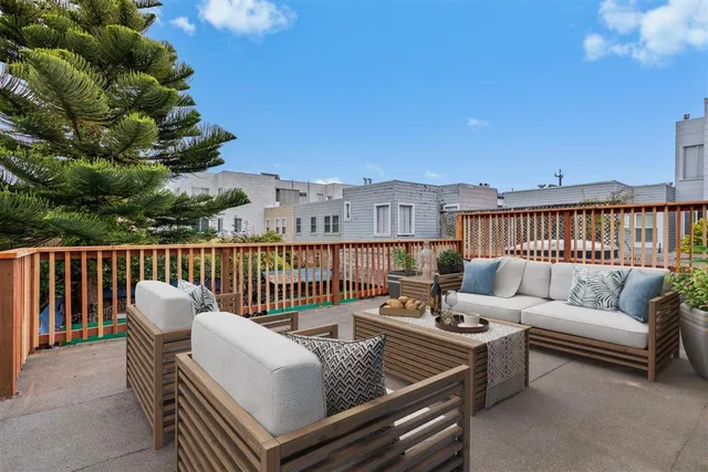 a view of a patio with couches table and chairs and potted plants