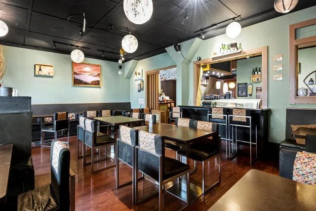 a kitchen with stainless steel appliances granite countertop a table and chairs in it
