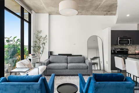 a living room with furniture a fireplace and a floor to ceiling window