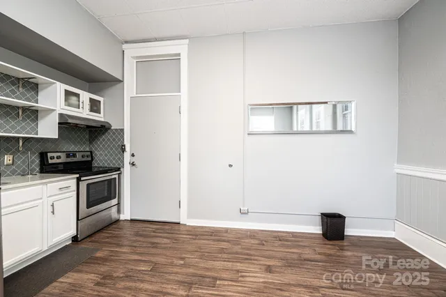 a kitchen with stainless steel appliances a stove and a white cabinets