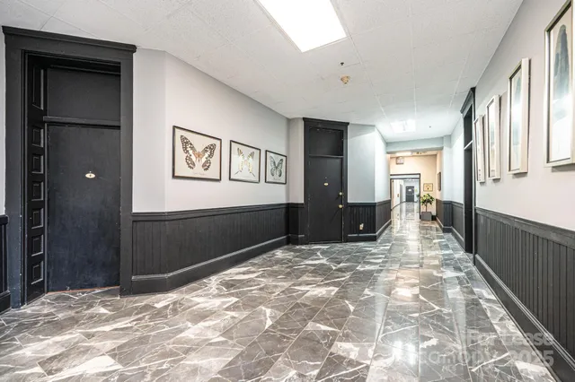 a view of a hallway with wooden floor and livingroom
