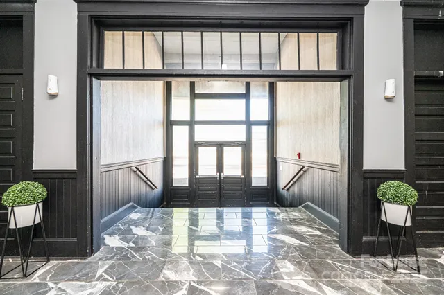 a living room with wooden floor and a potted plant