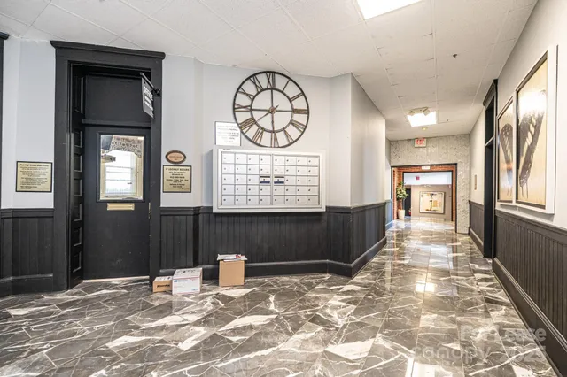 a view of a hallway with wooden floor and a chandelier