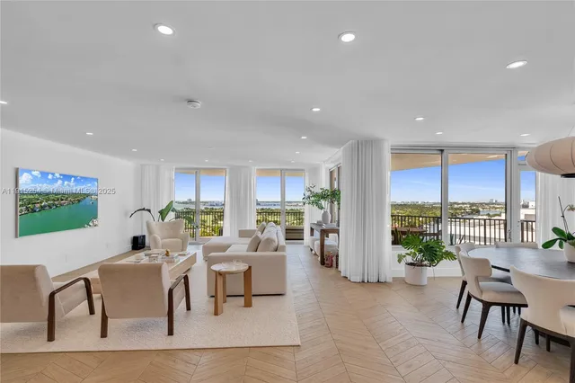 a living room with furniture a large window and kitchen view