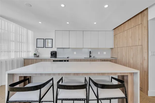 a kitchen with a dining table chairs and white cabinets
