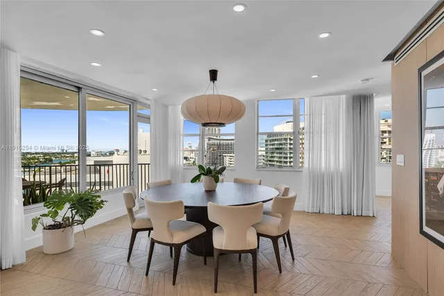 a dining room with furniture potted plants and wooden floor