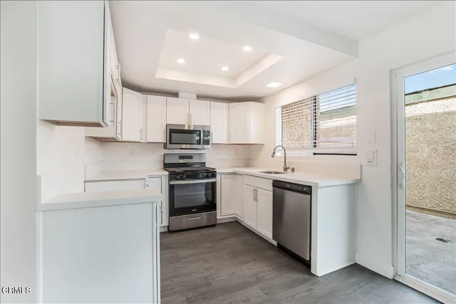 a kitchen with stainless steel appliances granite countertop a sink and a stove
