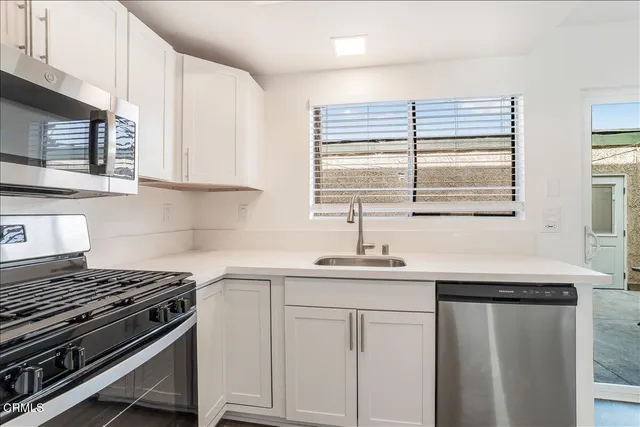 a kitchen with stainless steel appliances white cabinets and a sink