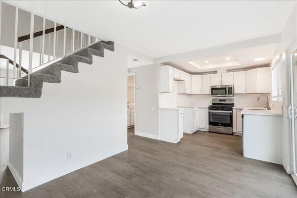 a room with white cabinets and stainless steel appliances