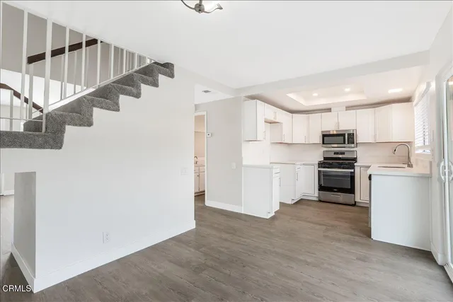 a room with white cabinets and stainless steel appliances