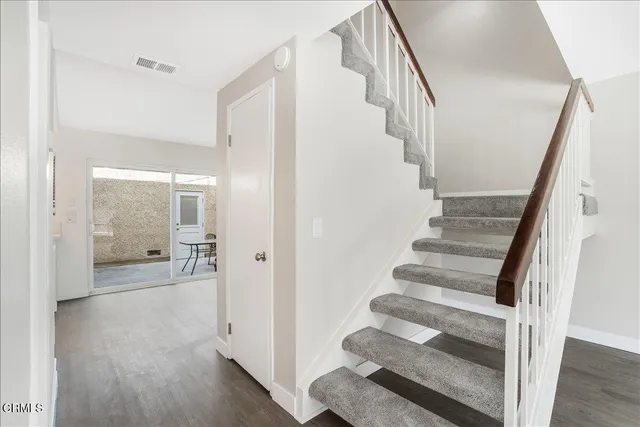 a view of a hallway with wooden floor and entryway