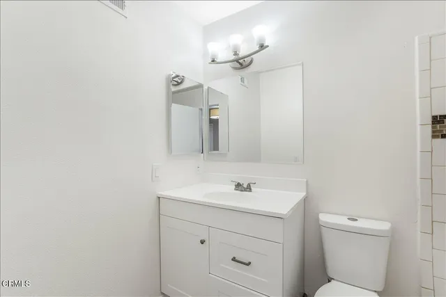 a bathroom with a sink a light fixture and a mirror