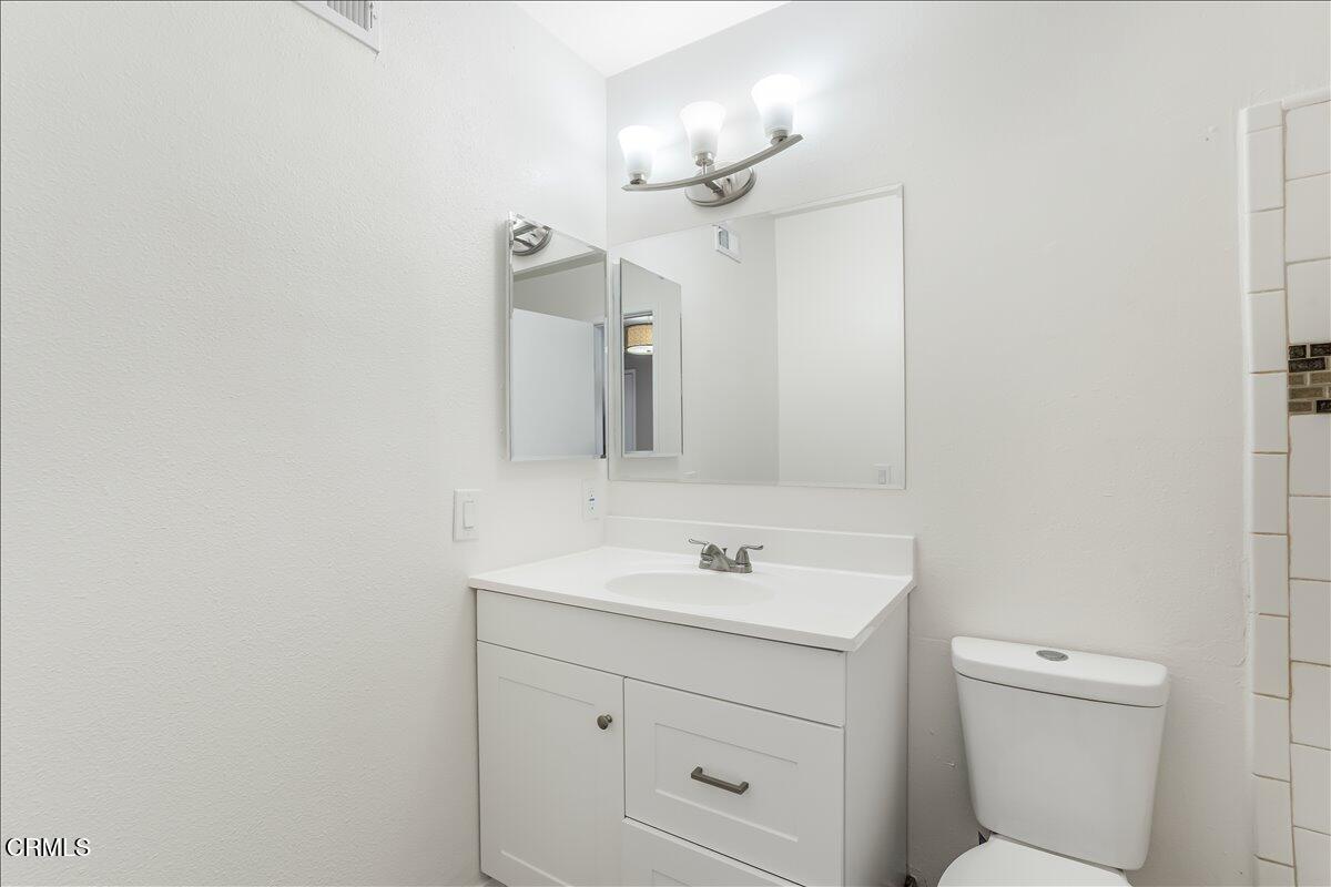5147 Perkins Road Oxnard, CA 93033 - Photo 22 of 42 a bathroom with a sink a light fixture and a mirror