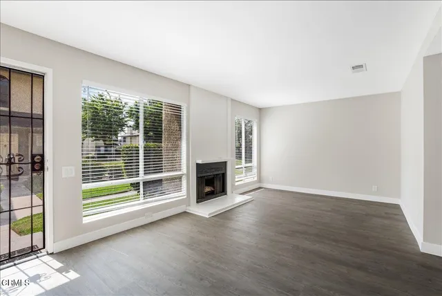 a view of a livingroom with a fireplace wooden floor and window