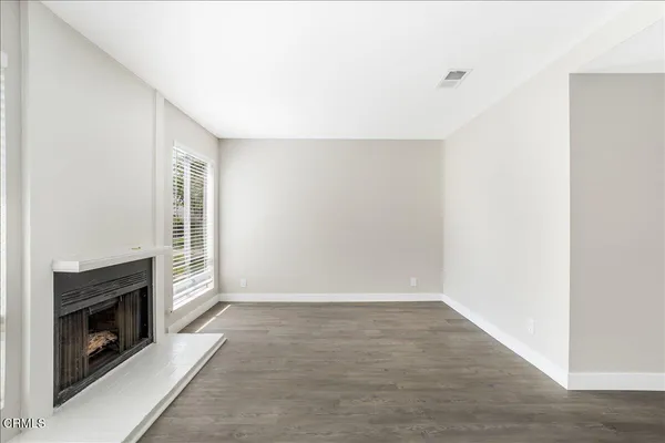 an empty room with windows and fireplace