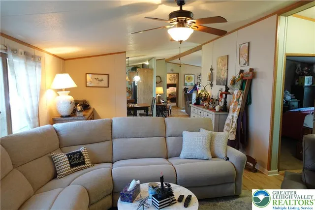 a living room with furniture and a ceiling fan