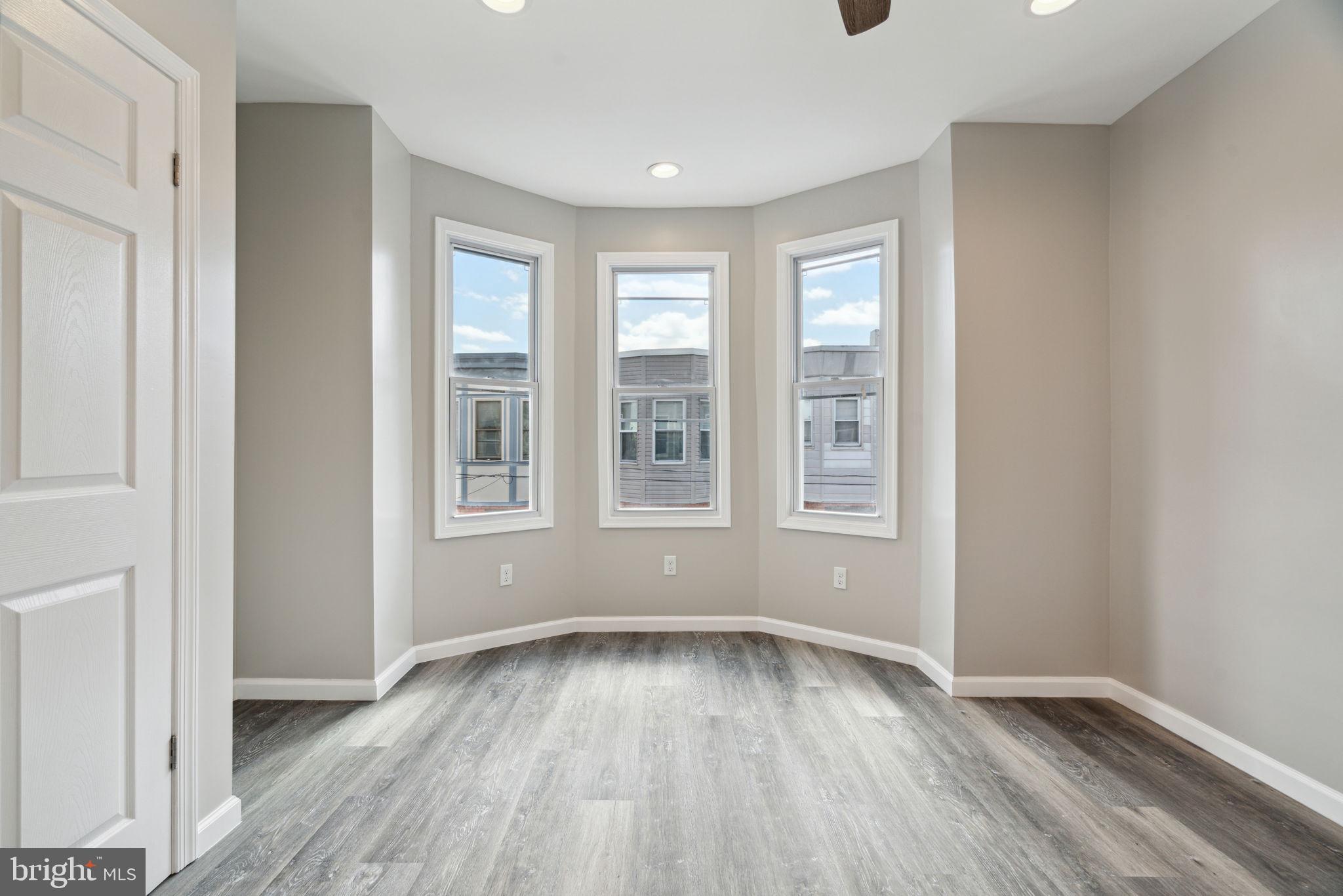 2033 Emily Street Philadelphia, PA 19145 - Photo 36 of 42 an empty room with wooden floor and windows