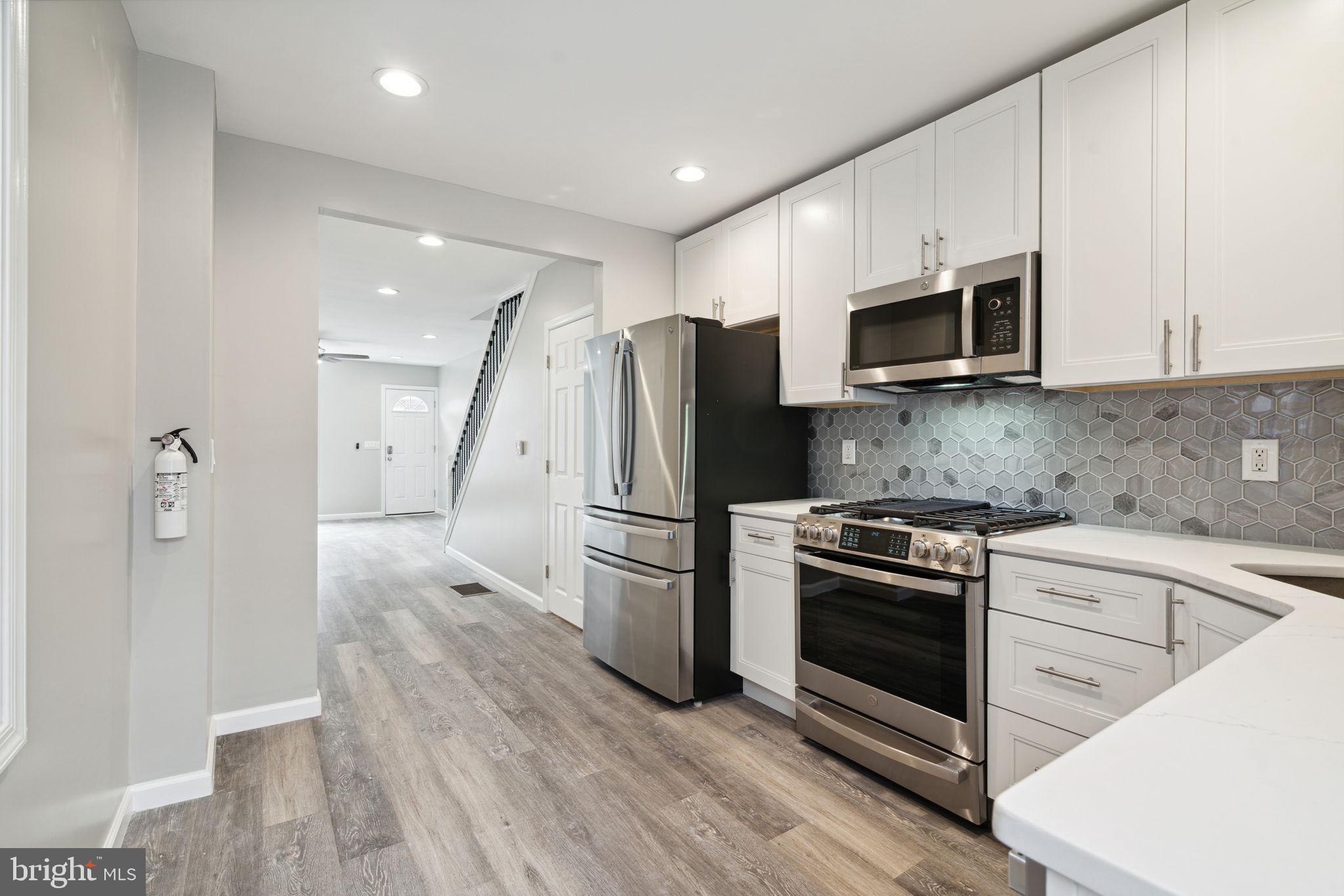 2033 Emily Street Philadelphia, PA 19145 - Photo 9 of 42 a kitchen with stainless steel appliances a stove a microwave and a hard wood floors