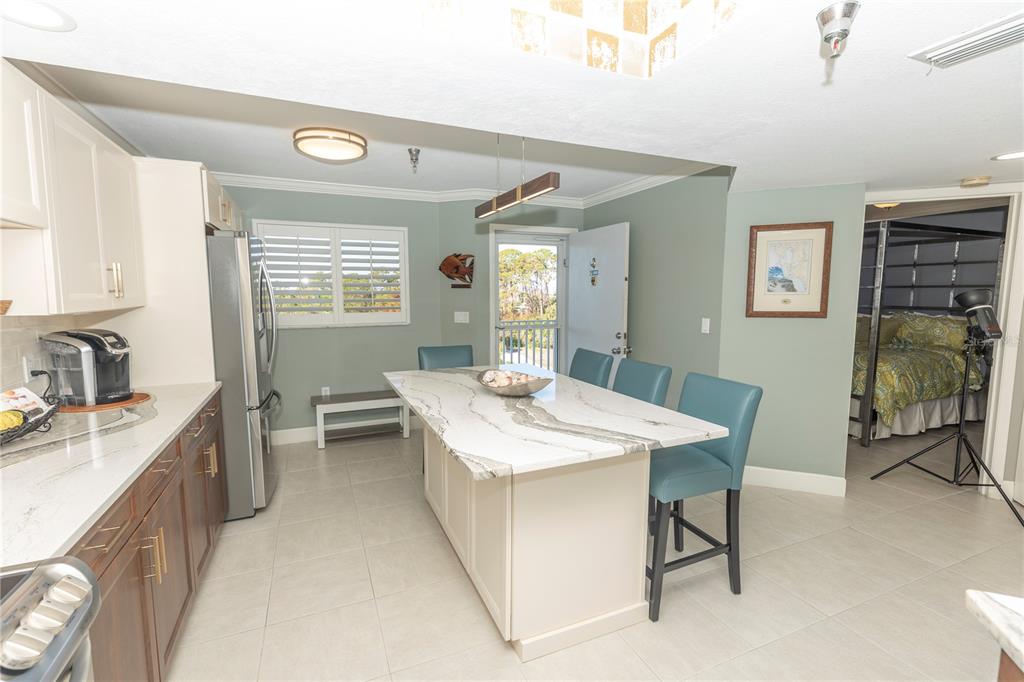 1401 South McCall Road, Unit B306 Englewood, FL 34223 - Photo 9 of 25 a kitchen with a table chairs sink and cabinets