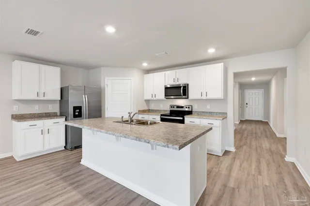 a kitchen with granite countertop a sink stove and refrigerator