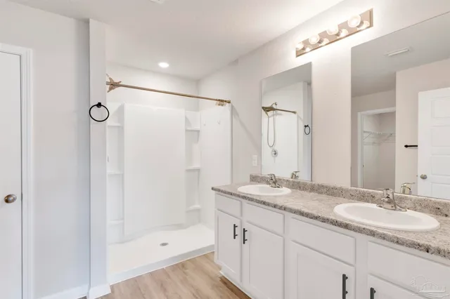 a bathroom with a shower sink and mirror