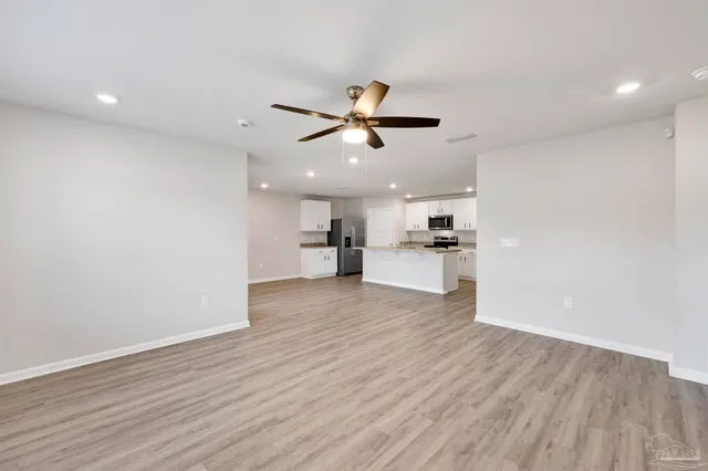 a view of a kitchen with a sink and dishwasher a refrigerator with wooden floor