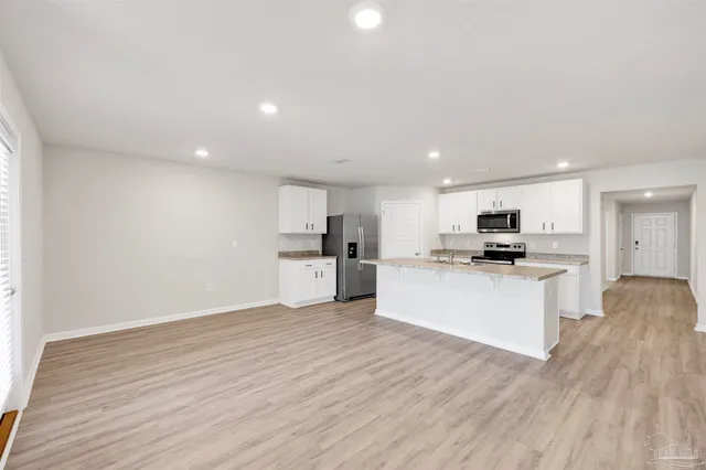 a kitchen with stainless steel appliances kitchen island sink and refrigerator