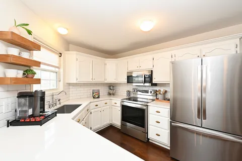 a kitchen with stainless steel appliances a sink cabinets and a refrigerator