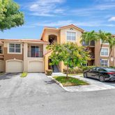 a front view of a house with a garden and parking