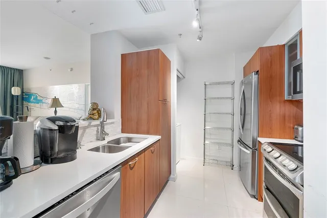 a kitchen with sink refrigerator and microwave