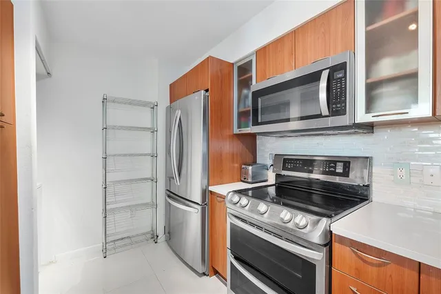 a kitchen with cabinets and steel appliances