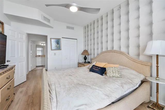 a bedroom with a large bed and a flat tv screen on dresser