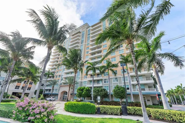 a front view of multi story residential apartment building with yard and green space