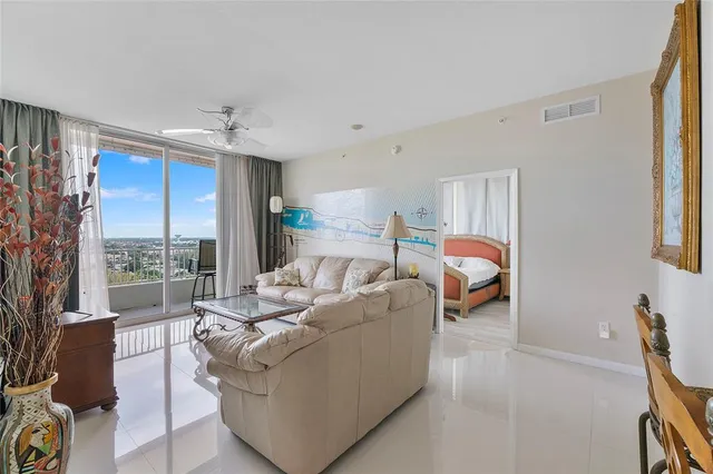 a living room with furniture a large window and a chandelier