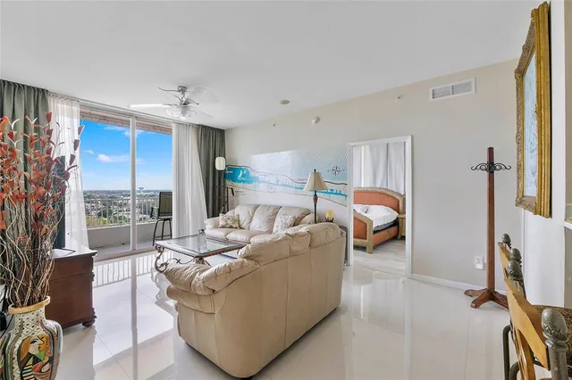a living room with furniture a large window and a flat screen tv